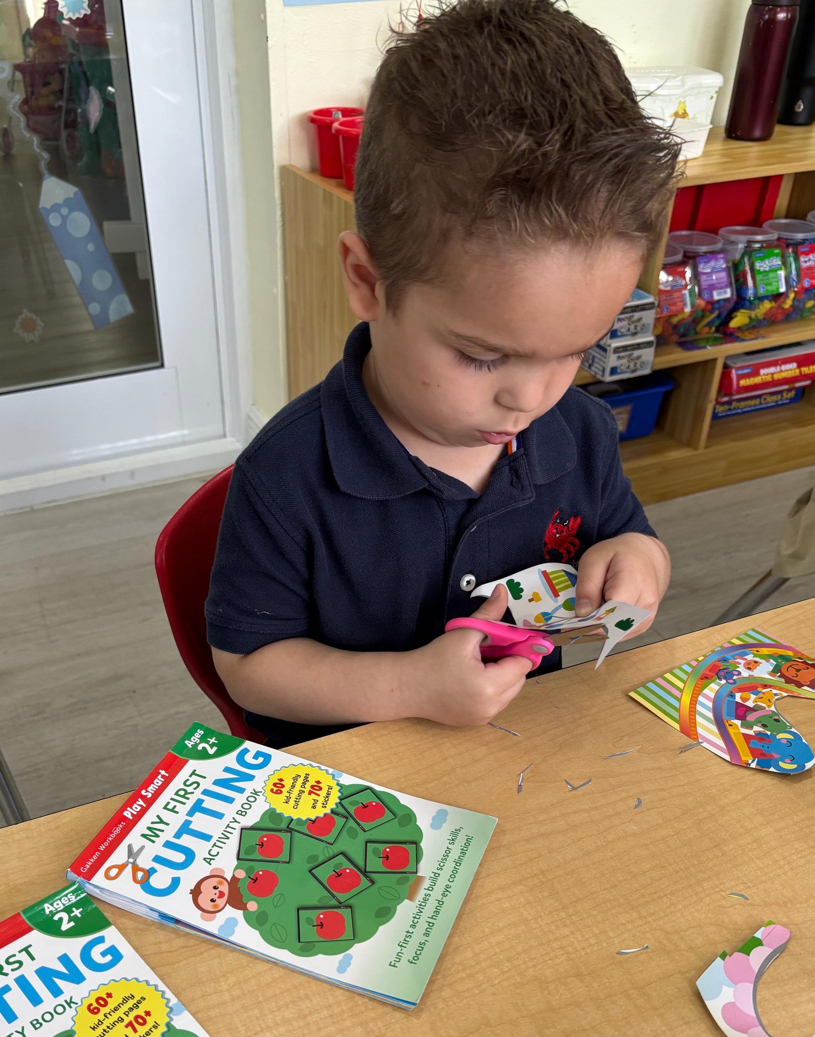 Child practicing cutting skills at Happy Little Crabs Child Care